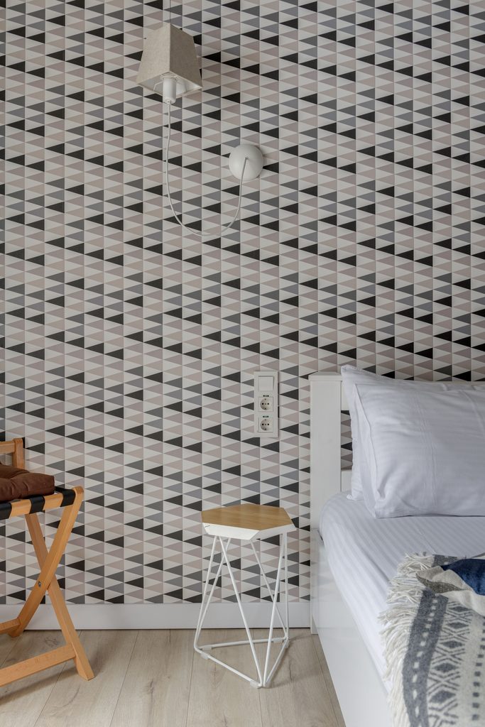 geometric peel and stick wallpaper accent wall in a modern bedroom
